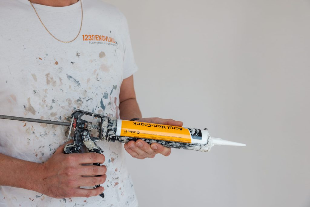 Medewerker van 123Renovlies met kitpistool in de hand