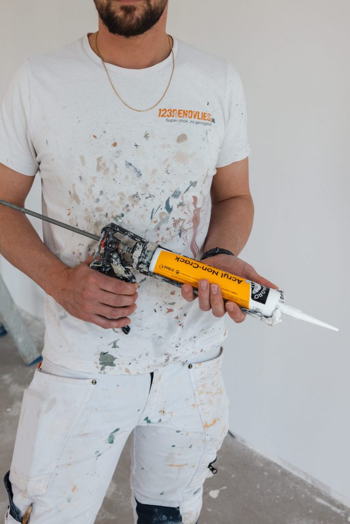 Medewerker van 123Renovlies met kitpistool in de hand