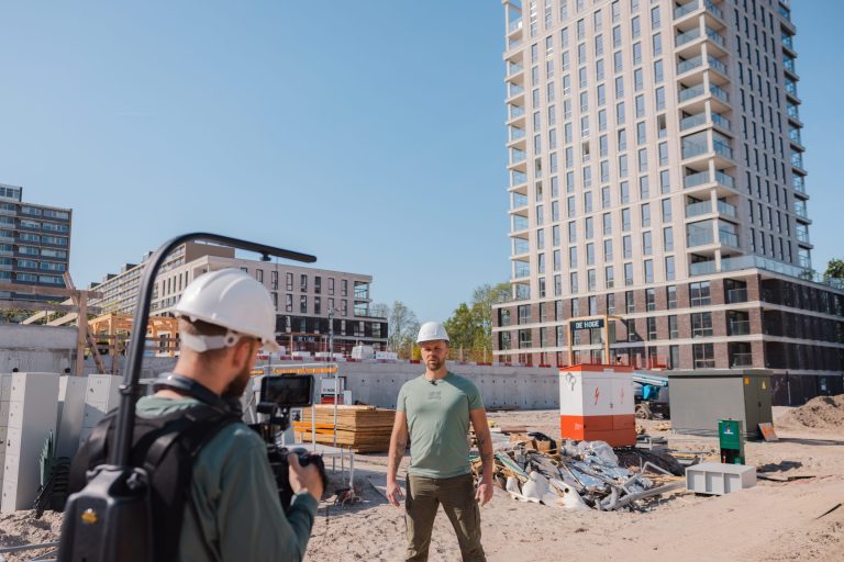 Bouwplaats met nieuwbouw appartementen en twee mannen met helm